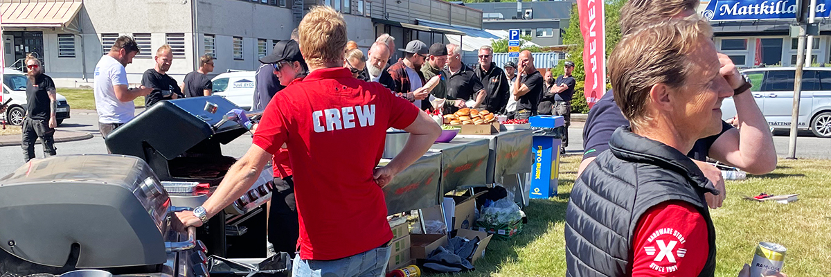 bannerbild på människor som är på event och en man i röd tröja står vid en grill