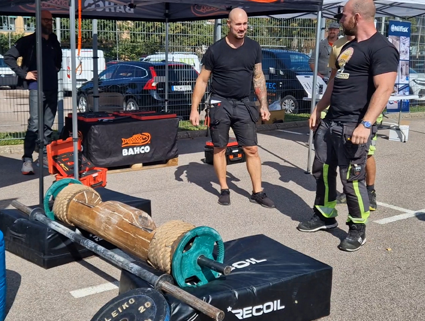 två människor på ett event som står framför en skivstång