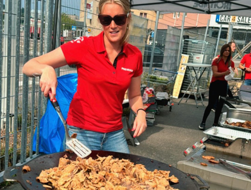 en tjej som står och steker kebabkött på en häll