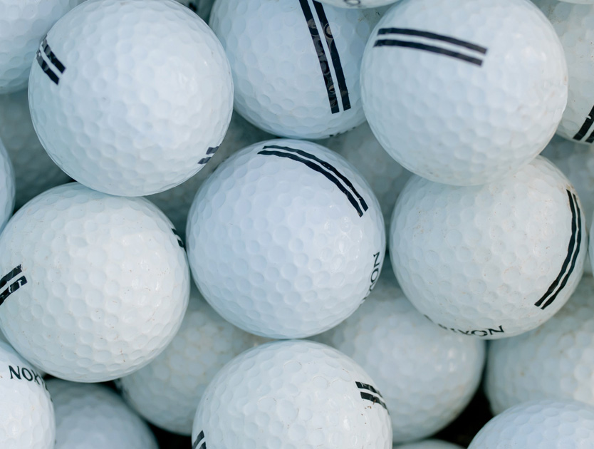 närbild på golfbollar