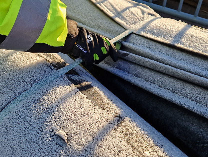 närbild på en handske med frost i bakgrunden